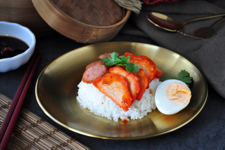 Cantonese style BBQ pork with rice serve on golden dish with chopsticks on backgroundの写真素材