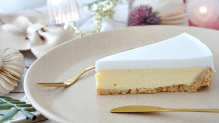 Close up piece of cheesecake on plate with wedding party decoration on background