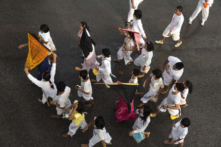 PHUKET, THAILAND - OCTOBER 1 2011: An entourage of attendants accompany two Mah Song (spirit...