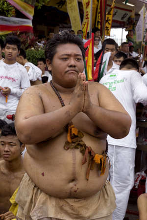 PHUKET, THAILAND - OCTOBER 2 2011: A worshiper clasps his hands in prayer and devotion during the Phuket Vegetarian Festival at the Bang Niew Chinese Shrine in Phuket Town.のeditorial素材