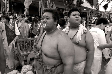 PHUKET, THAILAND OCTOBER 2 2011: Two acolytes return to the Bang Niew Chinese Srhine after the conclusion of a street procession during the annual Phuket Vegetarian Festival.のeditorial素材