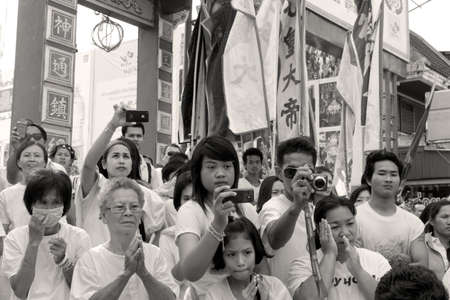 PHUKET, THAILAND OCTOBER 2 2011: A throng of spectators at the annual Phuket Vegetarian Festival snap photos of a street procession in front of the main gate of the Bang Niew Chinese Shrine in Phuket Town. のeditorial素材