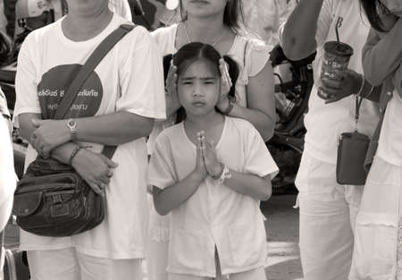 PHUKET, THAILAND OCTOBER 2 2011: A young devotee in Phuket Town clasps her hands in prayer during the annual Phuket Vegetarian Festival.のeditorial素材
