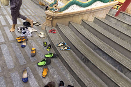 PHUKET, THAILAND APRIL 28 2013: A western tourist removes her shoes before entering Phuket's largest Buddhist temple, Wat Chalong.のeditorial素材