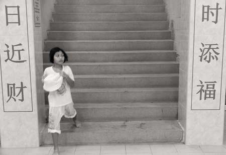 PHUKET, THAILAND OCTOBER 5 2011: A young devotee in ceremonial white rushes down a staircase at the Sui Boon Tang Chinese Shrine in Phuket Town during the annual Phuket Vegetarian Festival. のeditorial素材