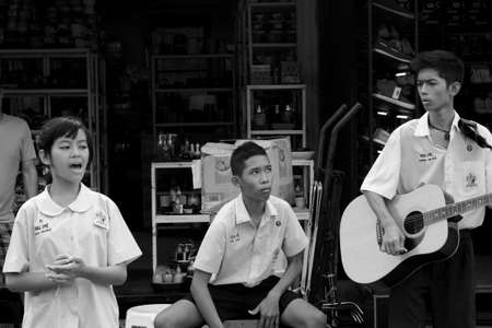 BANGKOK, THAILAND MARCH 18 2012: A trio of Thai student street musicians perform for the crowds at the Chatuchak Weekend Market in Bangkok. のeditorial素材