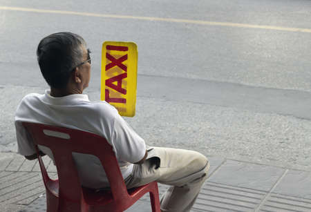 PHUKET, THAILAND FEBRUARY 24 2012: A cabbie flashes a for hire sign while waiting for a fare on Sainamyyen Road in Patong Beach. のeditorial素材
