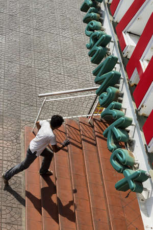 PHUKET, THAILAND FEBRUARY 28 2012: A delivery guy sprints into the entrance of the Banzaan Fresh Market in Patong Beach.のeditorial素材