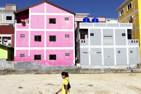 PHUKET, THAILAND JULY 26 2012: A Thai woman walks by an empty construction site on way home from work.のeditorial素材