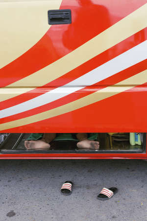 BEACH ROAD, PATONG, PHUKET, THAILAND AUGUST 20 2009: A bus driver on Patong Beach takes a quick...