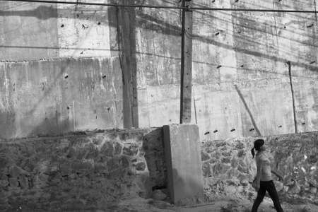 NAN NAI ROAD, PATONG, PHUKET, THAILAND DECEMBER 29 2012:  A woman walks home down a hill after work in Patong Beach.のeditorial素材