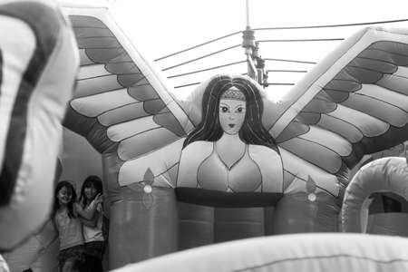 WAT KARON MARKET, KARON, PHUKET, THAILAND FEBRUARY 16 2013: Two girls play inside an inflatable playground during Market Day at Temple Karon in Phuket.のeditorial素材