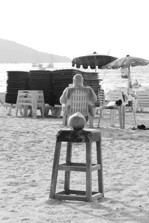 PATONG BEACH, PHUKET, THAILAND JANUARY 25 2013: A tourist reads a book in the late afternoon sun on Patong Beach in Phuket. のeditorial素材
