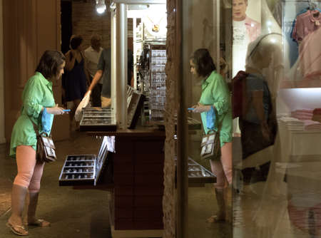 JUNGCEYLON MEGAMALL, PATONG, PHUKET, THAILAND JULY 27 2012: A woman on holiday in Phuket pauses to check out some items on sale at the Jungceylon Megamall in Patong Beach.のeditorial素材