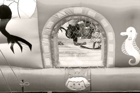 WAT KARON MARKET, KARON, PHUKET, THAILAND FEBRUARY 16 2013: A boy bounces and tumbles inside an inflatable playground during Market Day at Temple Karon in Phuket.のeditorial素材