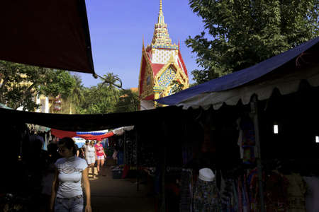 WAT KARON MARKET, KARON, PHUKET, THAILAND FEBRUARY 16 2013: A woman walks down a path past some open stalls selling clothes and garments on Market Day at Temple Karon in Karon Beach.のeditorial素材