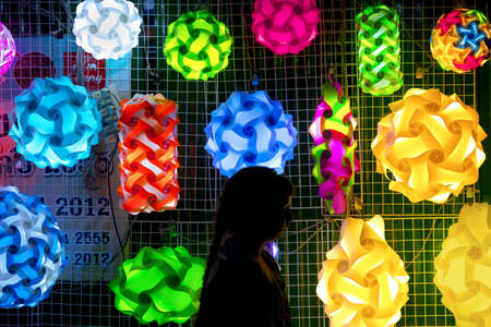 SOI BANGLA, PATONG, PHUKEt, THAILAND NOVEMEBER 20 2012: A young girl walks by a display of jigsaw lights at a street stall along Soi Bangla in Patong Beach.のeditorial素材