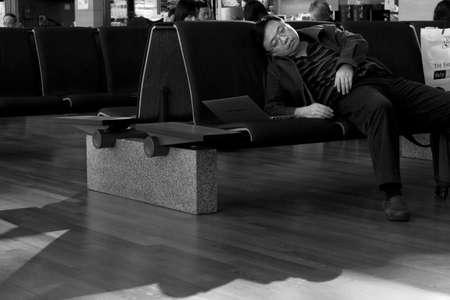 INCHEON AIRPORT, SOUTH KOREA NOVEMBER 22 2012: A passenger dozes off in front of his laptop while waiting to board a flight at Incheon Airport in South Korean. のeditorial素材