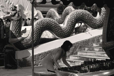 WAT KARON MARKET, KARON, PHUKET, THAILAND FEBRUARY 16 2013: A vendor sets up her wares at the Temple Market at Wat Karon in Phuket.のeditorial素材