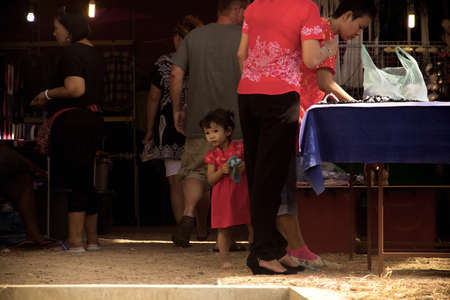 WAT KARON MARKET, KARON, PHUKET, THAILAND FEBRUARY 9 2013: A child works stands with her mom at their market stall in Temple Karon's temple market.のeditorial素材