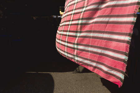 DOWNTOWN MARKET, PHUKET TOWN, PHUKET, THAILAND: APRIL 19 2013: A market stall vendor hangs a blanket as a sunscreen to ward off the hot afternoon sun at Downtown Market in Phuket Town.のeditorial素材