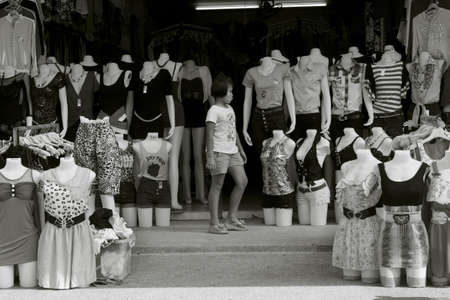 SAINAMYEN ROAD, PATONG, PHUKET, THAILAND MAY 21 2012: A young girl walks in between rows of mannequins displaying garments at a boutique in Patong Beach. のeditorial素材