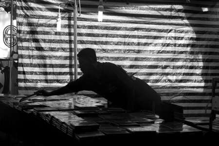 TEMPLE MARKET, KARON BEACH, PHUKET, THAILAND FEBRUARY 9 2013: A vendor arranges DVDs at his stall during Market Day at Temple Karon. のeditorial素材