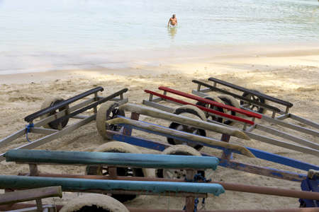 KAMALA BEACH, PHUKET, THAILAND JANUARY 26 2013: A swimmer wades through the surf in front of a row of jet ski tows at Kamala Beach during the high season in Phuket.のeditorial素材