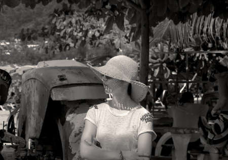 PATONG BEACH, PHUKET, THAILAND JANUARY 22 2013: Tourist uses large sombrero straw hat to avoid sunburn on Patong Beach. のeditorial素材