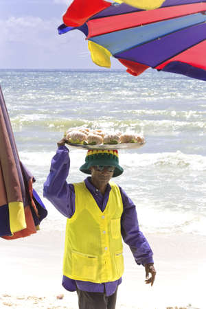 PATONG BEACH, PHUKET, THAILAND AUGUST 6 2011: A beach peddler carries a tray of fresh pomelos.のeditorial素材