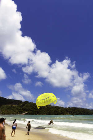 PATONG BEACH, PHUKET, THAILAND AUGUST 4 2011: A parasail operator assists a customer in taking off from Patong Beach.のeditorial素材