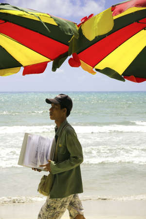 PATONG BEACH, PHUKET, THAILAND AUGUST 6 2011: A beach peddler carries designs for henna temporary tattoos. のeditorial素材