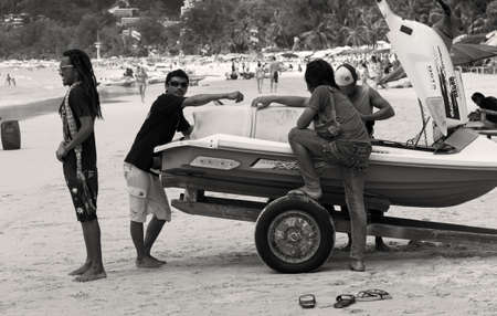 PATONG BEACH, PHUKET, THAILAND AUGUST 23 2011: A group of jet ski rental operators take a short break on Patong Beach. のeditorial素材