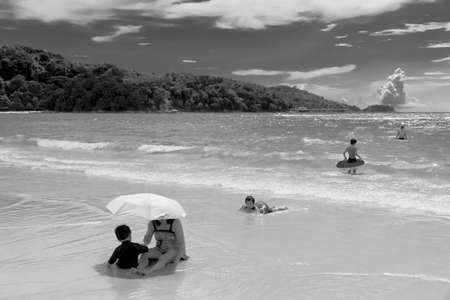 PATONG BEACH, PHUKET, THAILAND AUGUST 23 2011: A mother and son share a moment under the sun on Patong Beach in Phuket. のeditorial素材