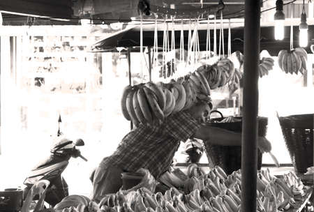 KATHU MARKET, KATHU, PHUKET, THAILAND MAY 13 2013: Banana vendor gives banana to customer.のeditorial素材