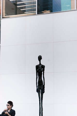 THE SCULPTURE GARDEN, MoMA, NEW YORK CITY, USA, 27 JUNE 2010: An elderly woman sits next to a Giacometti sculpture in the Sculpture Garden at the Museum of Modern Art (MoMA) in Manhattan.のeditorial素材