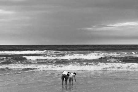 SABAH, EAST MALAYSIA; SEPTEMBER 30 2009: A young couple collects seashells in the surf at Pulau Kalampunian next to the Tip of Borneo island.のeditorial素材