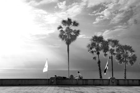 CAPE PROMTHEP POINT, PHUKET, THAILAND, 30 NOVEMBER 2013: Tourists rest on wall of a vista point at...