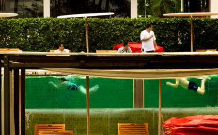 KATA BEACH, PHUKET, THAILAND, 1 AUGUST 2013: Tourists at a resort swim in a transparent pool.のeditorial素材