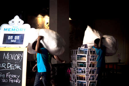 OLD TOWN PHUKET, PHUKET, THAILAND, 6 JANUARY 2014: Workers for a laundry service pick up linen and...