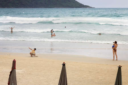 KATA BEACH, PHUKET, THAILAND, 1 AUGUST 2013: Tourists play in the surf at Kata Beach.のeditorial素材