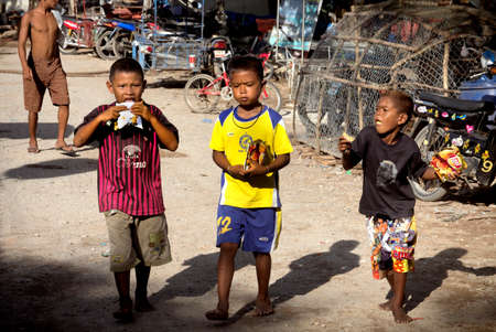 RAWAI BEACH, PHUKET, THAILAND, 11 MAY  2014: ThreeThai schoolboys enjoy munchies after school.のeditorial素材
