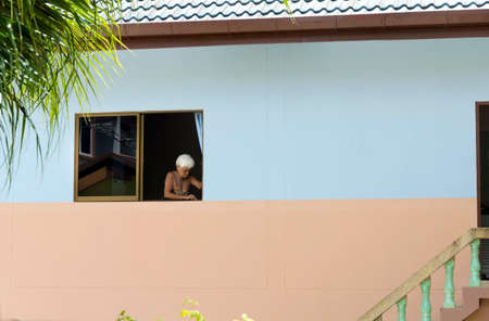 PATONG BEACH, PHUKET, THAILAND, 28 JULY 2012: A landlord cleans the window sill of a rental unit.のeditorial素材
