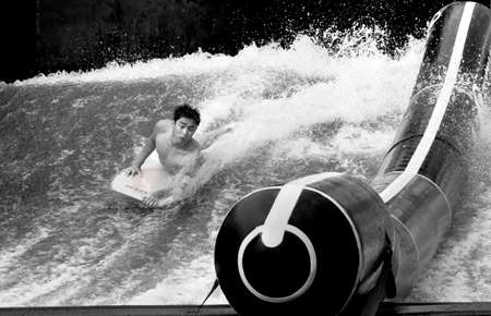 PHUKET, THAILAND FEBRUARY 15 2013: A teenager rides a board on an artificial wave machine at an outdoor restaurant and bar in the beach side resort of Kata in Phuket.のeditorial素材