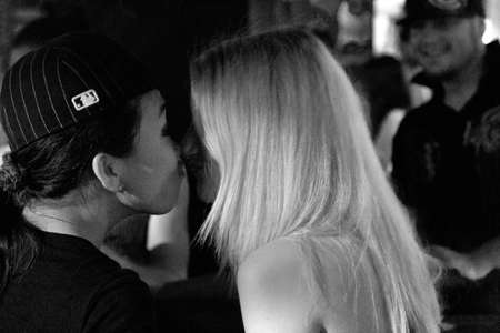 BANGLA RD., PATONG, PHUKET, THAILAND, 9 MAY 2012: Two female patrons at a disco on Bangla Road Pan share an intimate kiss while clubbing.のeditorial素材