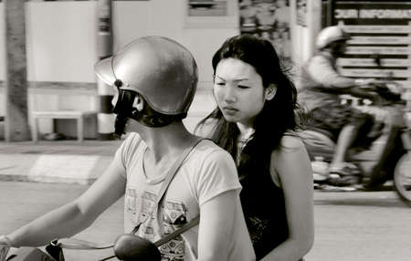 PHUKET, THAILAND 7 MAY 2012: Couple on scooter speeds through intersection in Phuket.のeditorial素材