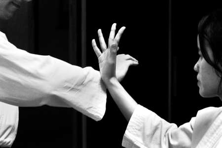 PHUKET TOWN, PHUKET, THAILAND, 3 MARCH 2014: A young Thai college student begins an arm lock technique with her black belt instructor.のeditorial素材