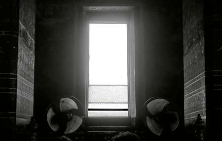 WAT PHO, BANGKOK, THAILAND, 26 SEPTEMBER 2014: Stand-up fans next to an open window provide cooling...