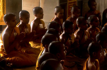 GOLDEN BUDDHA TEMPLE, BANGKOK, THAILAND, 28 SEPTEMBER 2014: A group of novice monks from the Meditation Education Training Treatment Academy (METTA) in India  pray to the Golden Buddha during a visitのeditorial素材