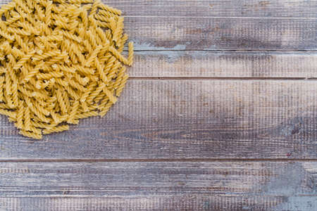 a lot of pasta on a wooden background, stacked in a bunch, place for text, for a logoの写真素材